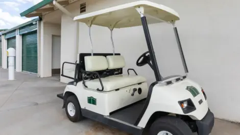 Golf cart parked in front of storage units.