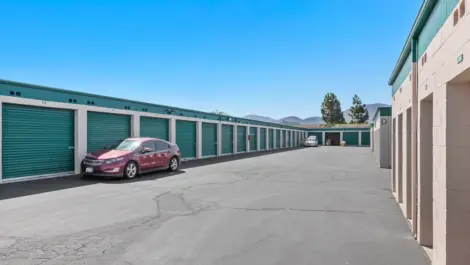Car parked near outdoor green storage units.