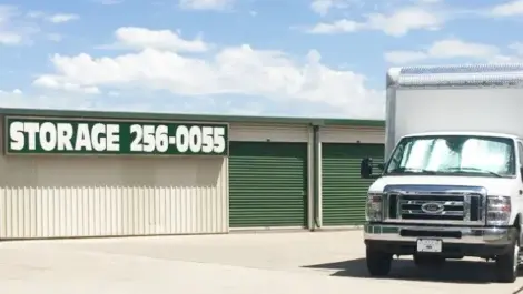 Storage sign and phone number near a moving truck.