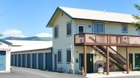 White storage facility office with a mountain in the background.